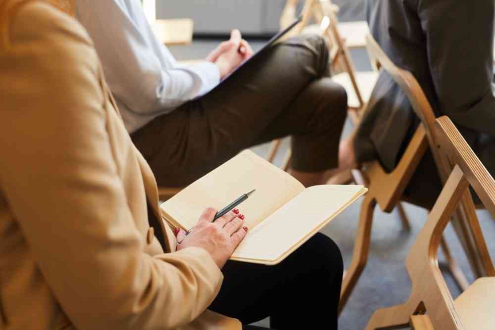 Businesswoman Taking Notes in Audience